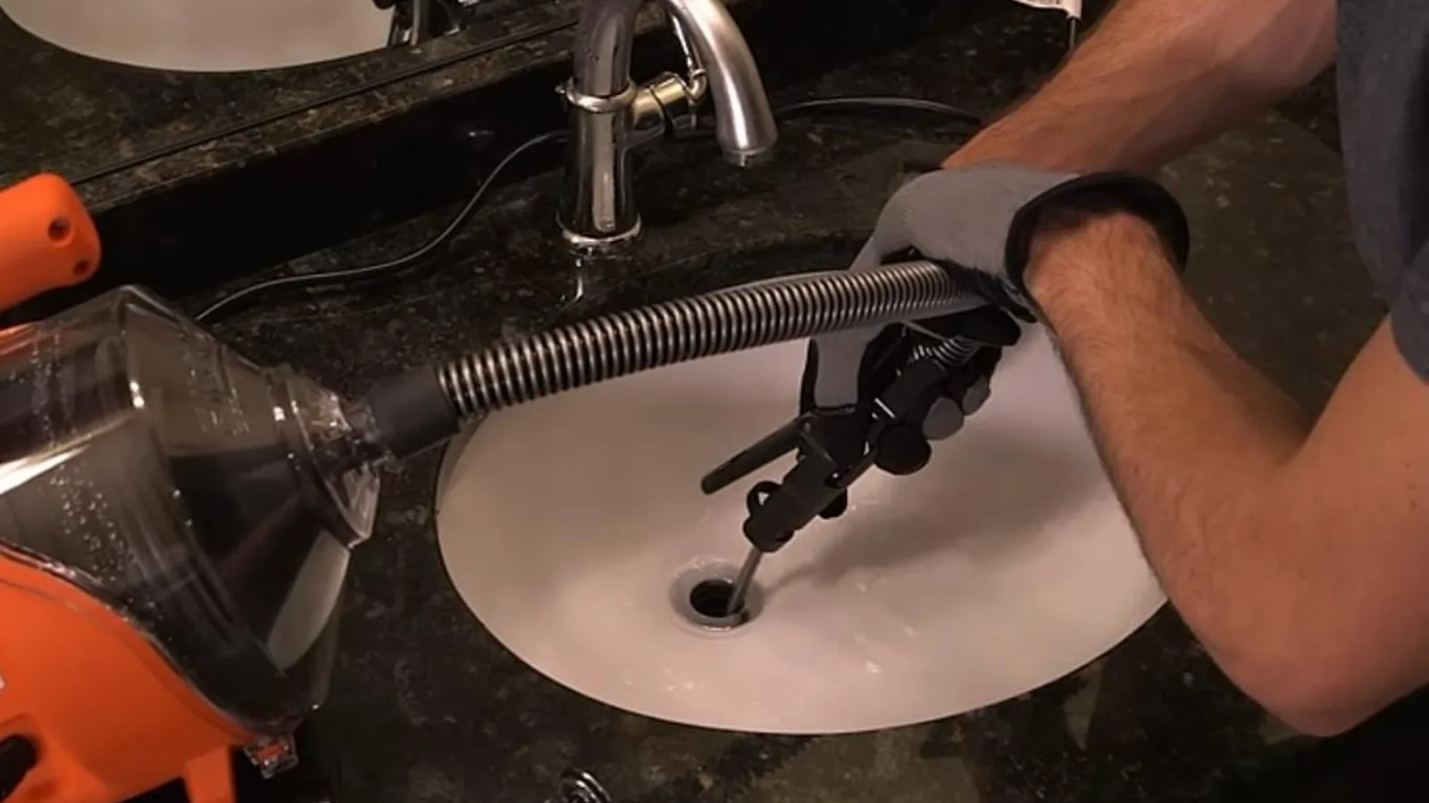 Drain auger cable running into a bathroom sink drain